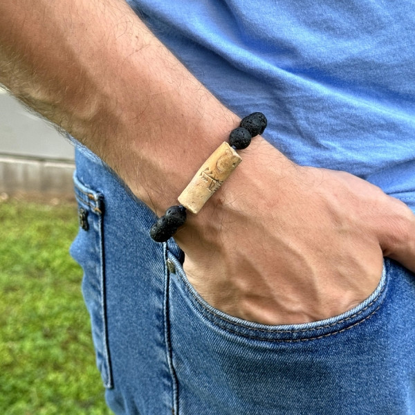 A Handcrafted Bracelet Made of Natural Stones, Featuring a Cylindrical Bead Engraved with The Word Freedom in Ancient Sumerian Script